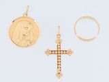 un gros plan d'une croix en or et d'une pièce de monnaie posées sur une surface blanche