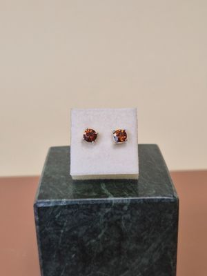 un gros plan sur une paire de boucles d'oreilles posées sur un bloc de marbre