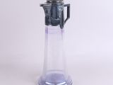 un pichet en verre surmonté d'une théière