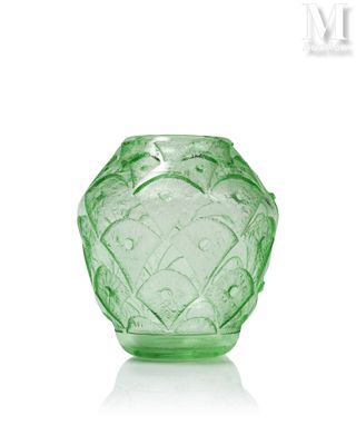 un vase en verre vert posé sur une surface blanche