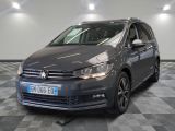 La Volkswagen Touran est garée dans une grande pièce au sol carrelé.