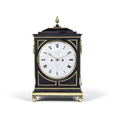 une horloge noire et dorée avec des chiffres romains