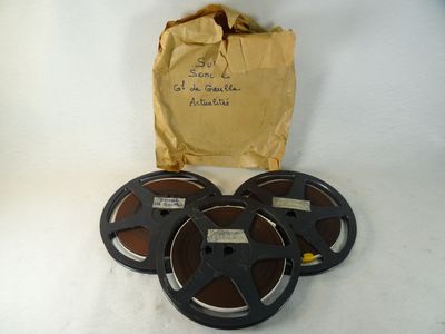 quatre bobines de film posées sur une table, à côté d'un sac