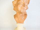 statue of a woman ' s head on a pedestal with a white base