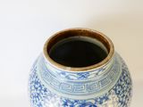 un vase bleu et blanc posé sur une surface blanche