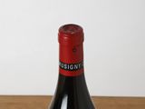 a bottle of red wine sitting on a wooden table