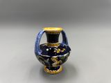 un petit vase bleu orné d'un motif doré