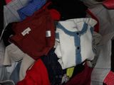 un tas de vêtements dans une valise sur laquelle est accrochée une étiquette