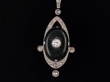 un pendentif Art déco orné d'une pierre d'onyx noir et de diamants