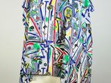 a woman ' s white top with multicolored designs on it
