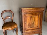un meuble en bois et une chaise dans une pièce