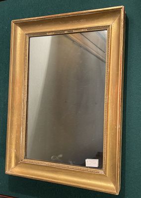 a mirror hanging on the wall next to a green wall