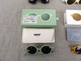several pairs of sunglasses and a pair of sunglasses are laid out on a table