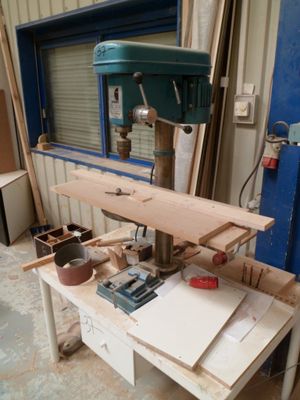 un établi avec une perceuse et une table sur laquelle sont posés des outils
