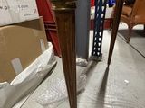a wooden table with two legs and a box on the floor