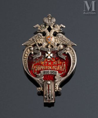 an image of a silver and red broochle with two birds on it