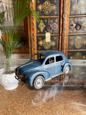 a toy car sitting on a glass table next to a potted plant