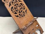 an old wooden stand with a carved design on it