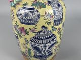 a yellow vase with blue and white designs on it
