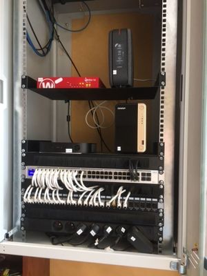 un rack sur lequel se trouvent de nombreux câbles et un ordinateur portable
