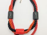 a close up of a necklace on a white surface