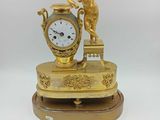 une horloge en or surmontée d'une statue