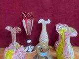 plusieurs vases en verre posés sur une table en bois, sur fond rouge