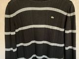 un pull rayé noir et blanc suspendu à un cintre