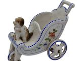 a figurine of a dog sitting in a baby carriage