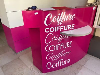 un comptoir rose et blanc sur lequel est accrochée une pancarte