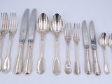 a lot of silverware on a table with a white background