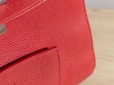 the inside of a red leather purse with a metal clasp