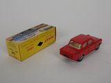 a red toy car next to a yellow box on a white surface