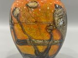 a vase with a painting on it sitting on a table