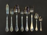 five spoons, two forks, and two spoons on a table