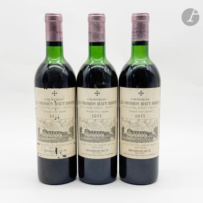 trois bouteilles de vin rouge posées l'une à côté de l'autre sur une surface blanche