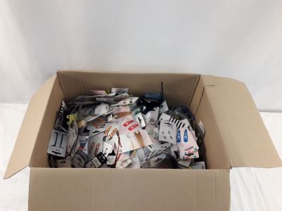 une boîte en carton remplie d'objets divers posée sur un lit