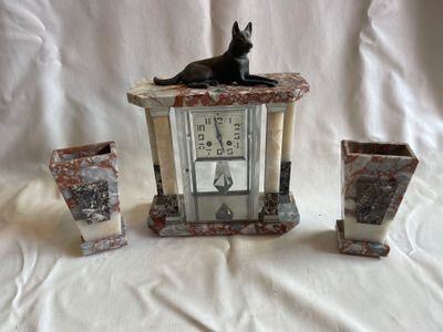 un chat noir assis sur une table, à côté de trois vases