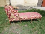 a red and gold chaise lounger sitting in the grass