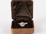 une bague en diamant dans un écrin en velours sur fond blanc