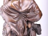 bronze statue of a man with a hat and a scarf on his head