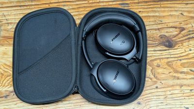 un casque audio dans son étui, posé sur une table en bois