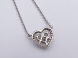 a close up of a heart shaped pendant on a chain
