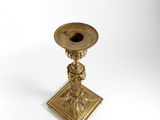 an antique brass candle holder on a white background