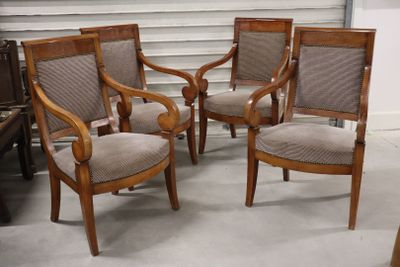 three wooden chairs in a room with a piano in the background