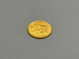 a close up of a gold coin on a gray surface