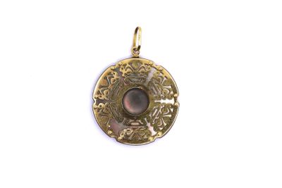 a close up of a gold pendant with a stone in the center