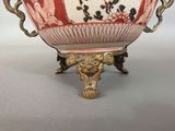 a large red and white bowl on a gold stand