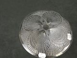 a silver plate with a fan on it on a table