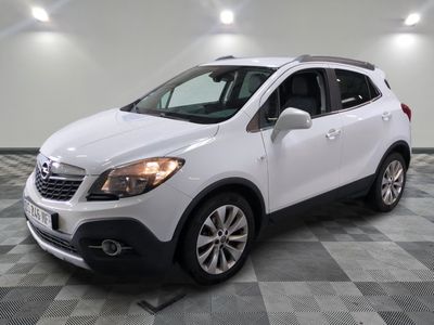 the white buick suv is parked on a checkered tile floor